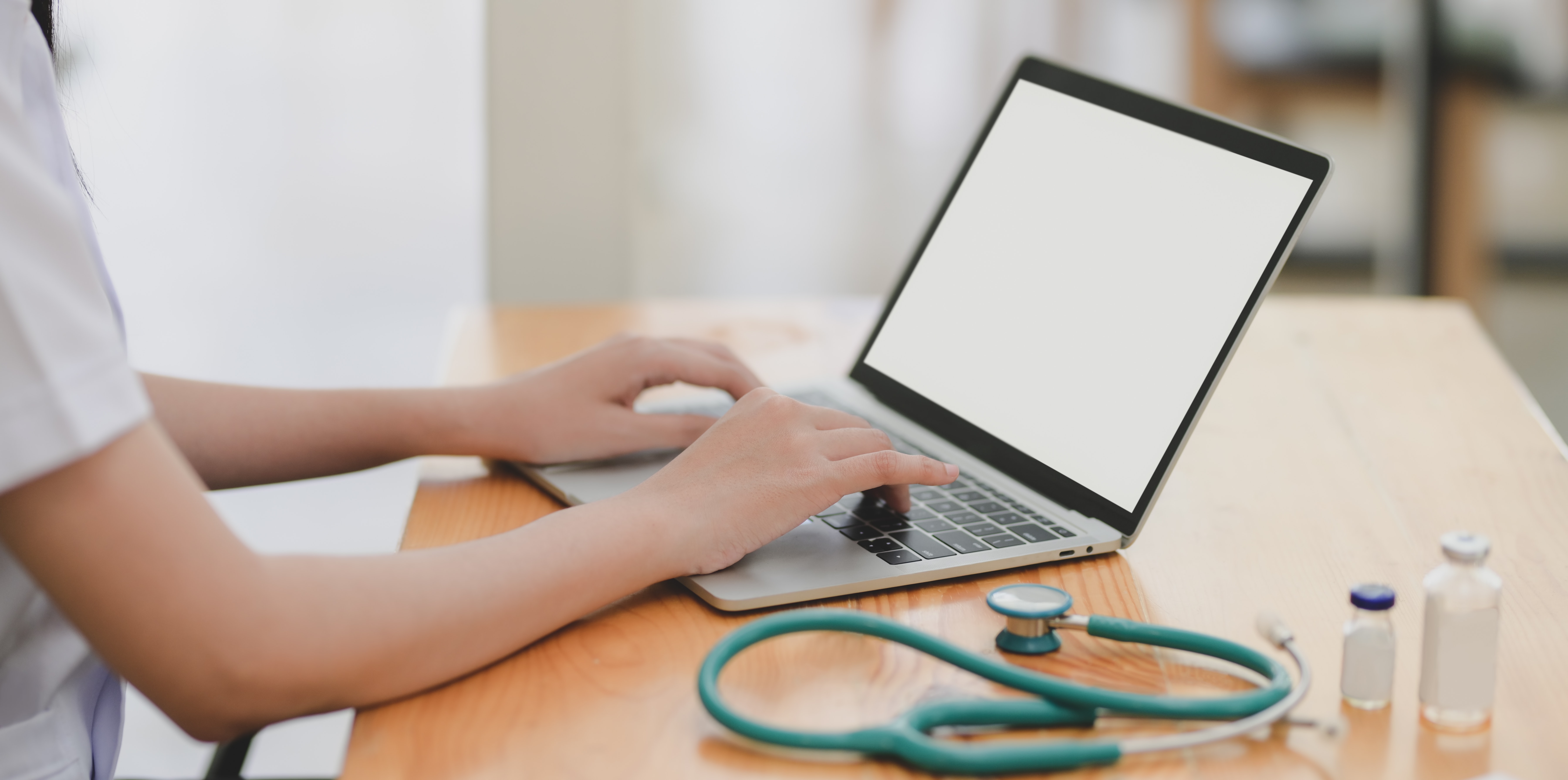laptop-near-teal-stethoscope-in-wooden-table-3758756
